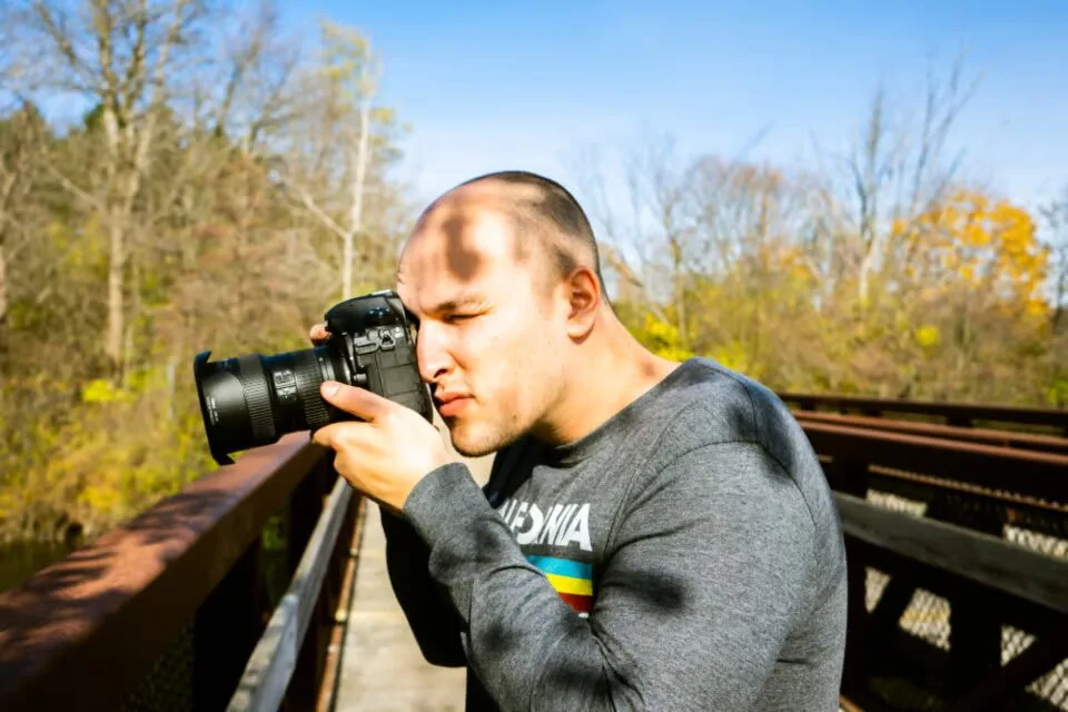 Photographer outdoors holding a camera ready to shoot