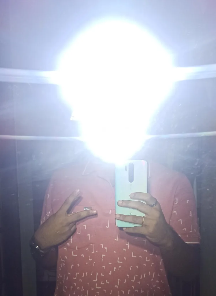 Harsh flash selfie in a bathroom mirror