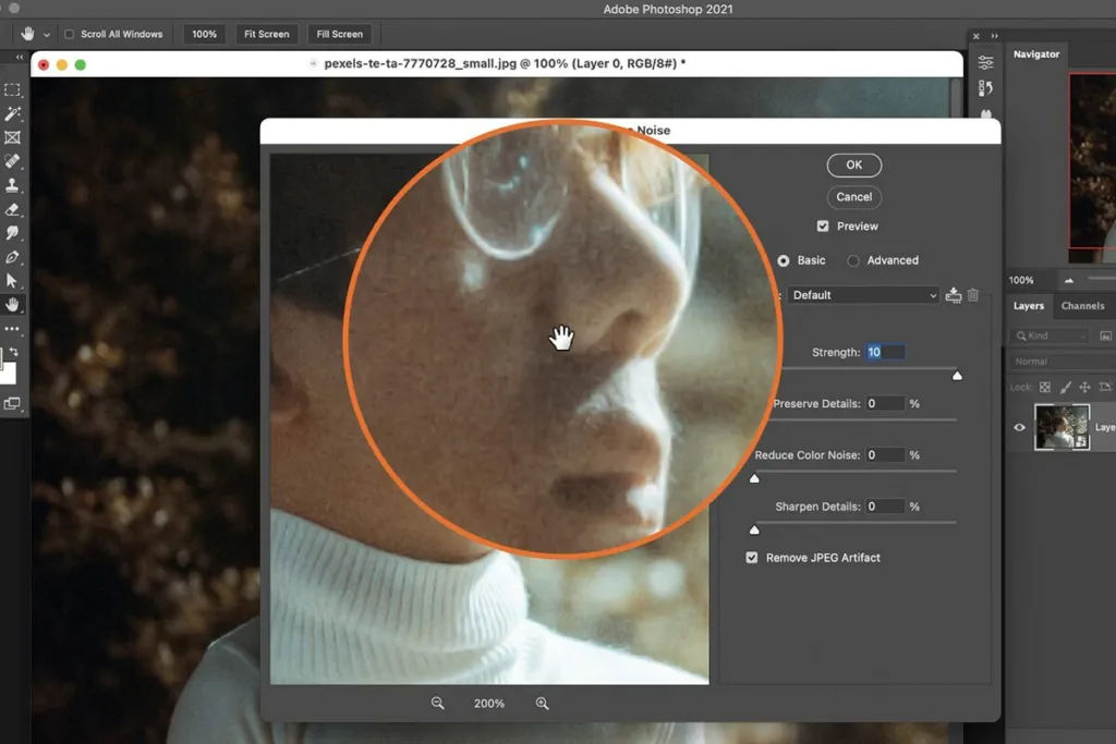 Photographer retouching noisy photos on a laptop in Photoshop