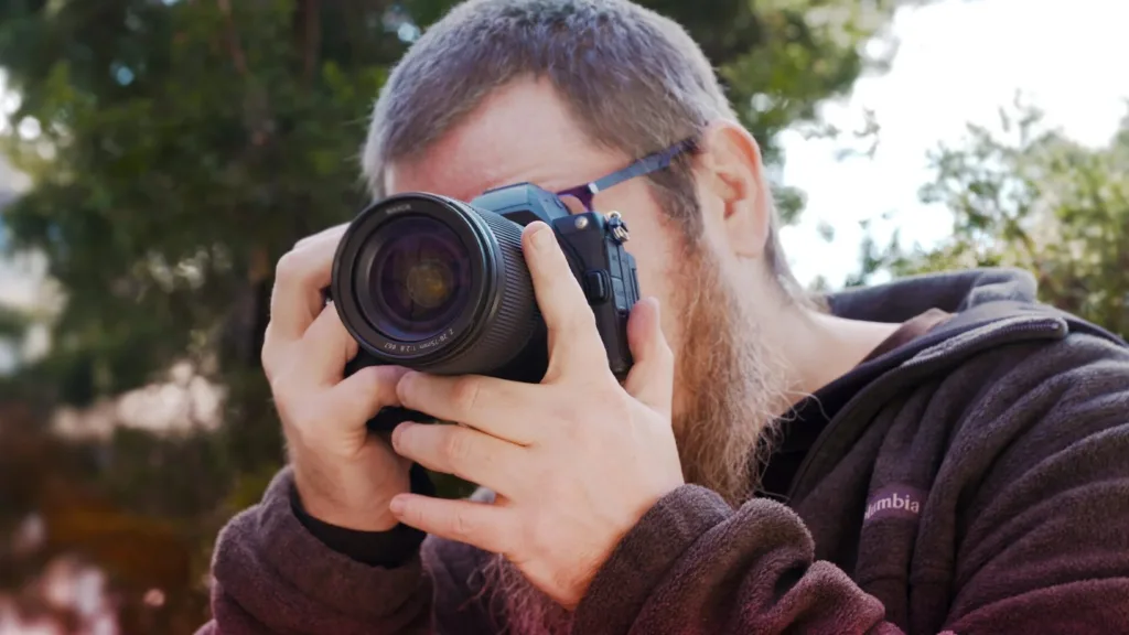 Photographer composing shot through camera viewfinder