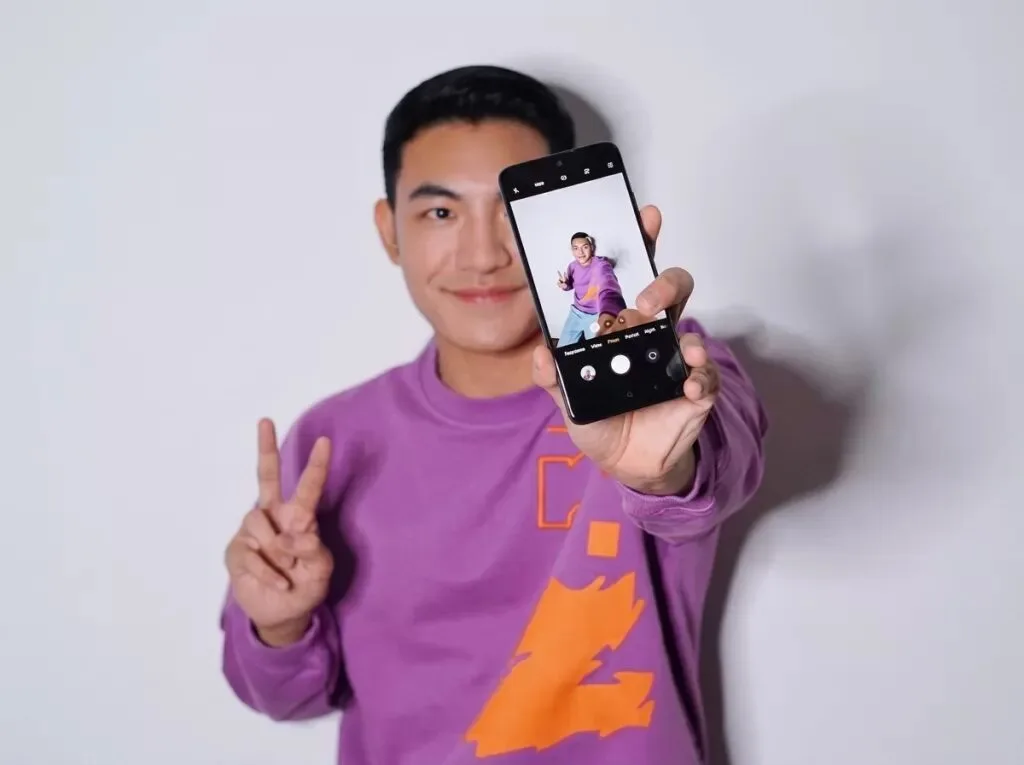 man taking a natural self-portrait using a rear camera
