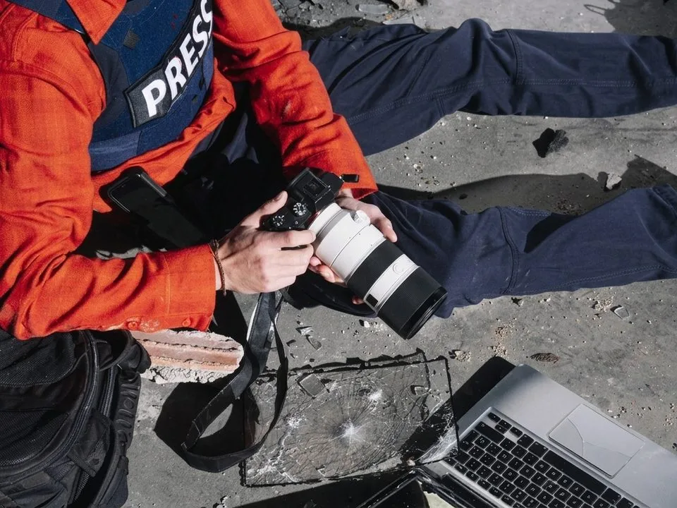 Photojournalist reviewing news photos on laptop